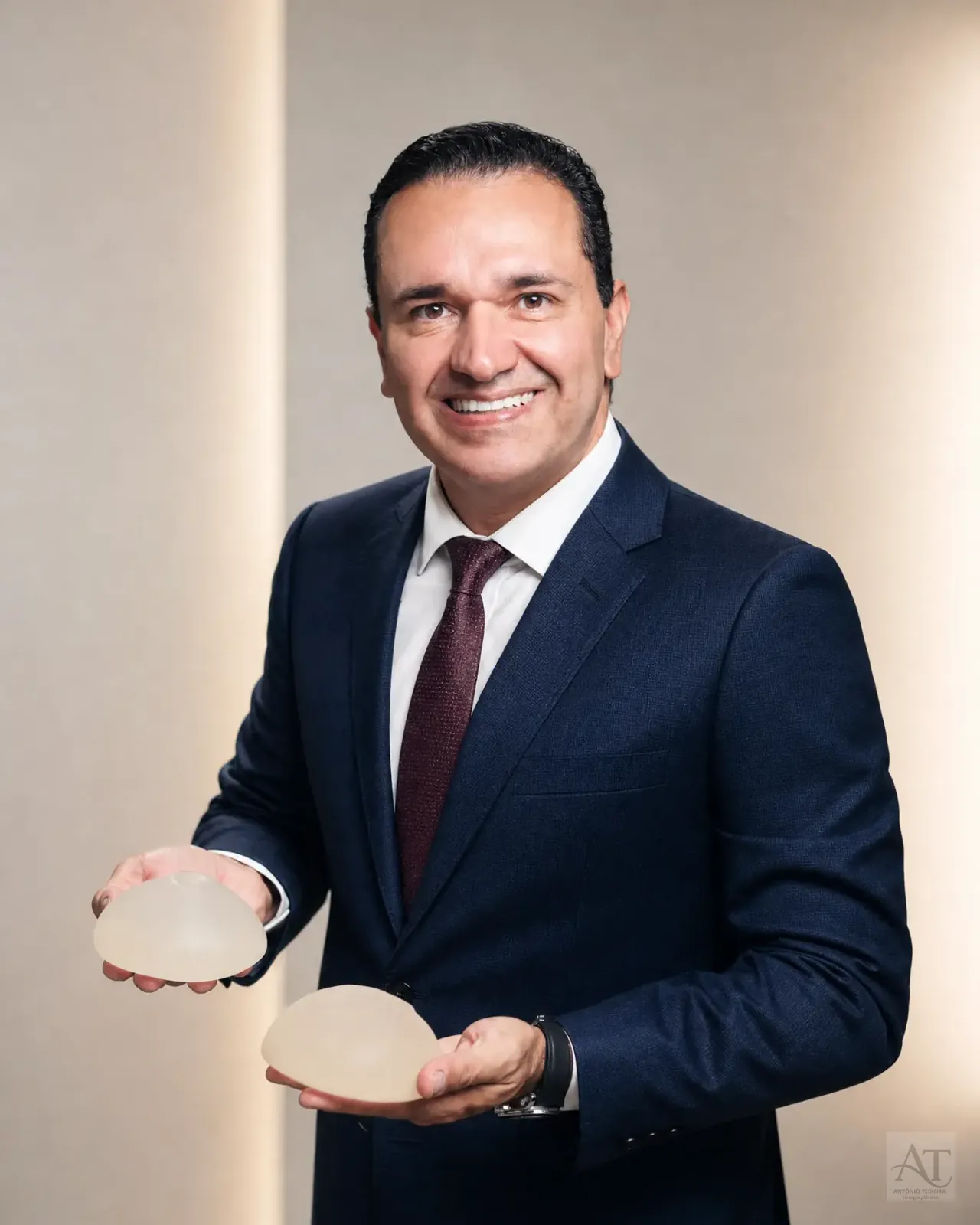 Dr. Antônio Teixeira segurando implantes mamários